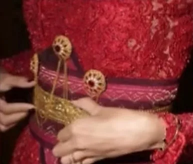 Detail sabuk emas di atas kebaya merah